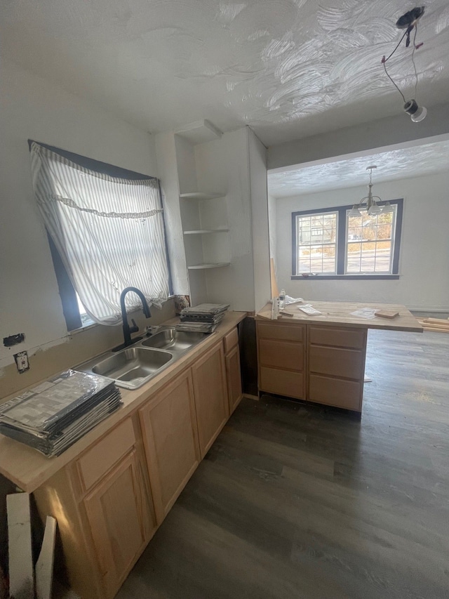 kitchen featuring dark hardwood / wood-style floors, light brown cabinetry, decorative light fixtures, sink, and kitchen peninsula