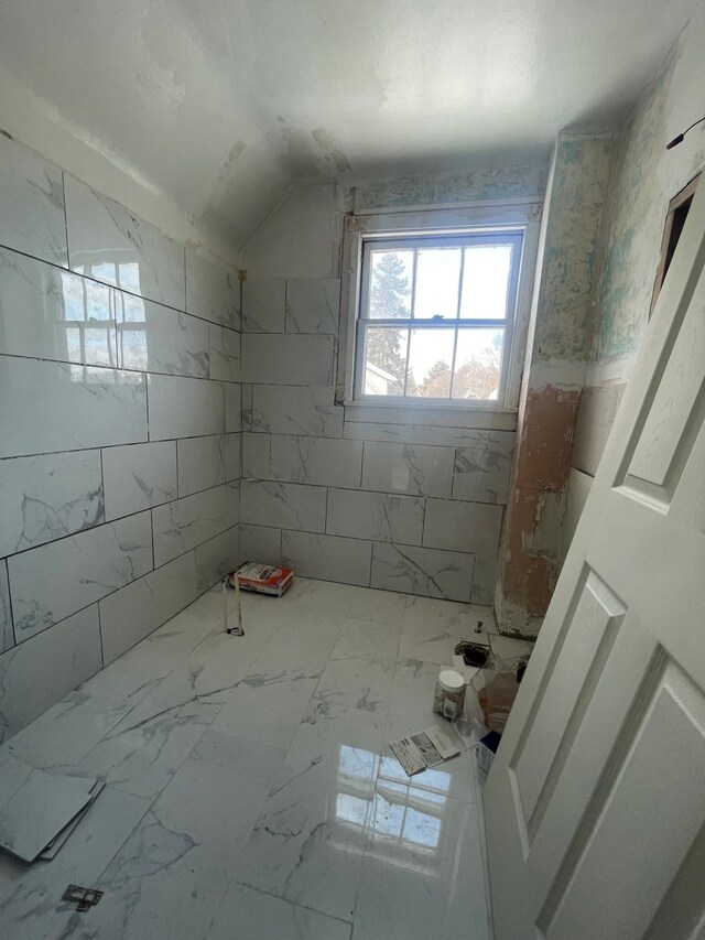 bathroom with vaulted ceiling and marble finish floor