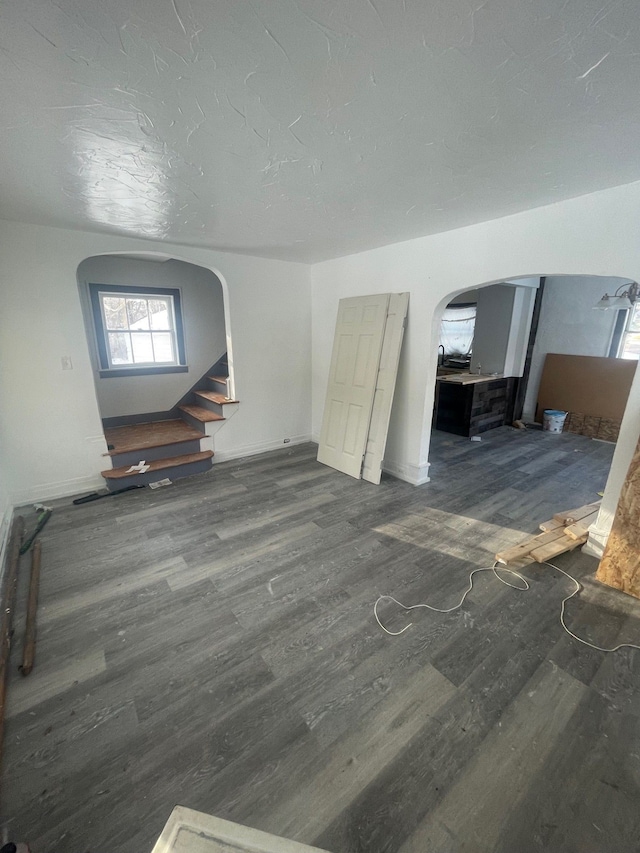 unfurnished living room featuring dark hardwood / wood-style floors and a textured ceiling