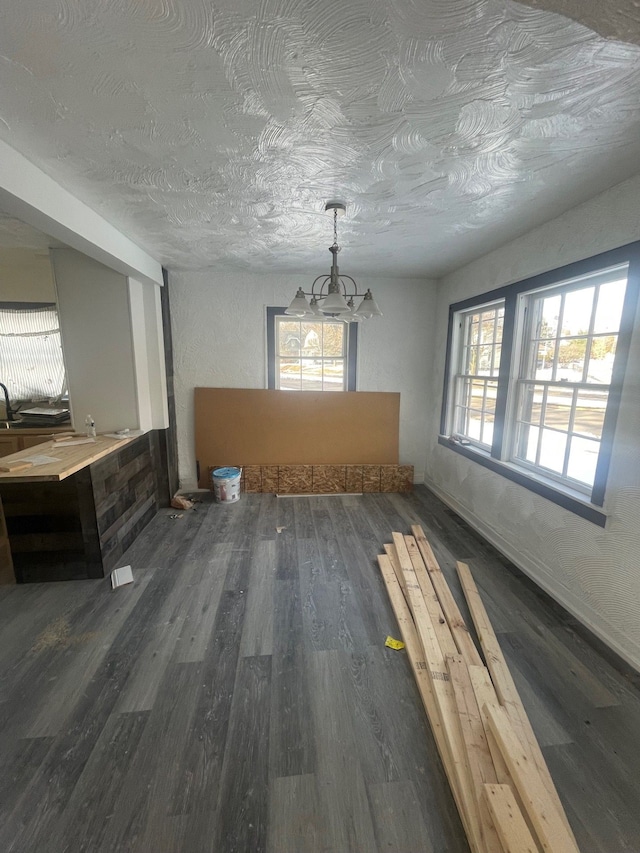 unfurnished dining area with dark hardwood / wood-style floors and a textured ceiling