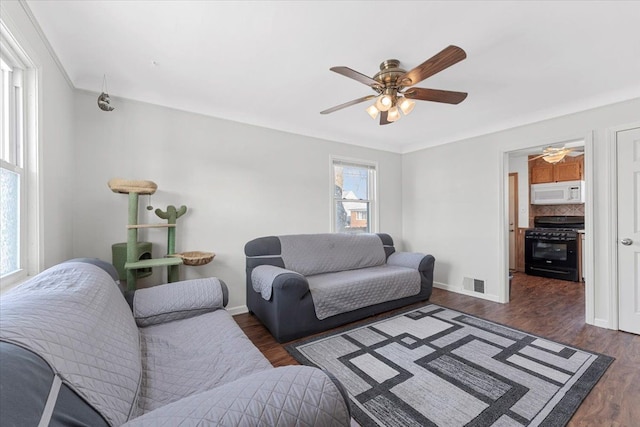 living room featuring dark wood-type flooring and ceiling fan