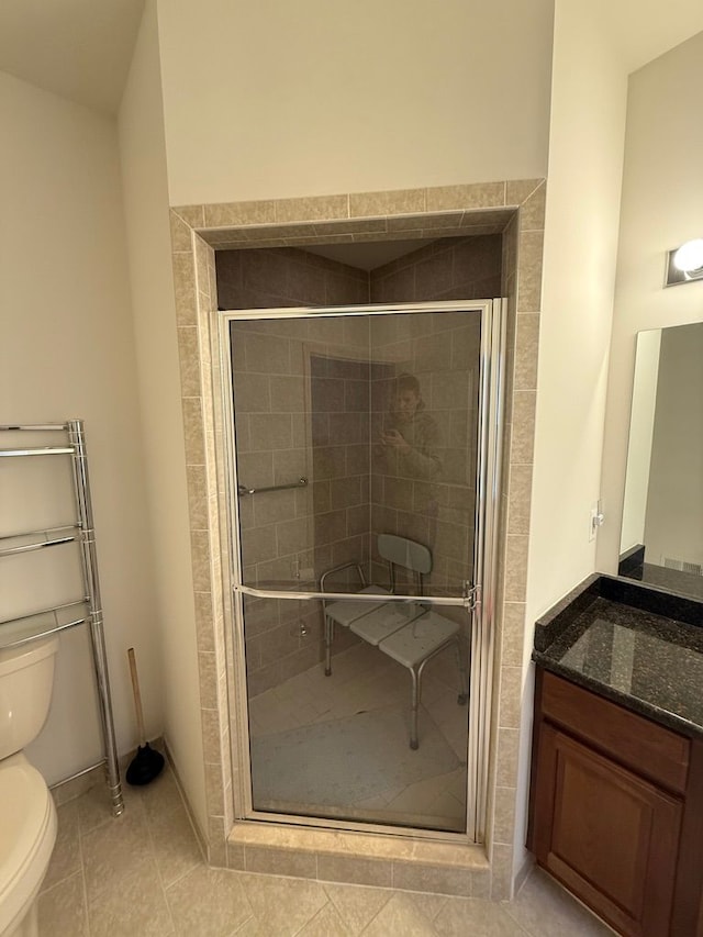 bathroom featuring vanity, tile patterned floors, toilet, and walk in shower