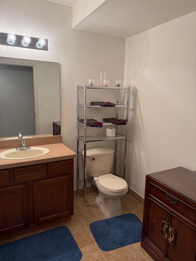 bathroom featuring vanity, toilet, and tile patterned flooring