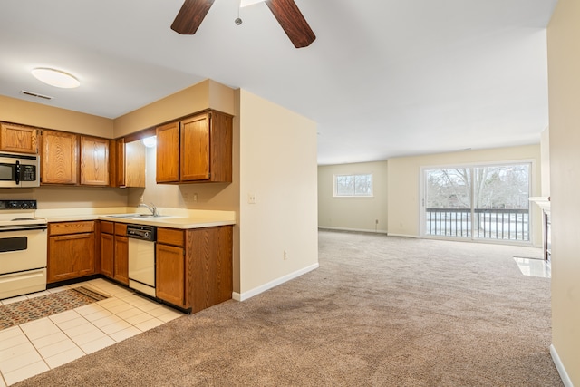 kitchen featuring ceiling fan, sink, light colored carpet, and white appliances