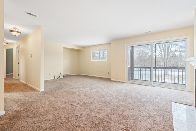 empty room with visible vents, baseboards, and carpet