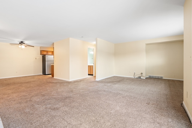 unfurnished living room with light colored carpet, ceiling fan, baseboards, and visible vents