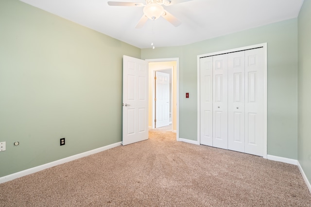 unfurnished bedroom with ceiling fan, light carpet, a closet, and baseboards