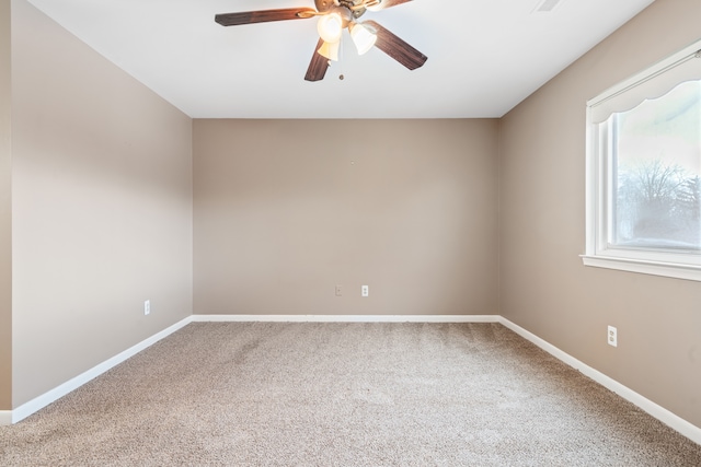 spare room with ceiling fan and carpet