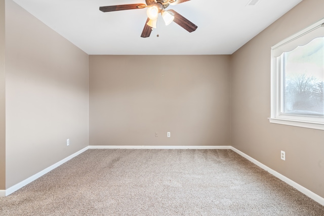 empty room featuring carpet flooring, baseboards, and a ceiling fan