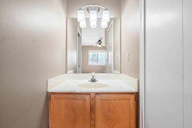 bathroom featuring ceiling fan with notable chandelier and vanity