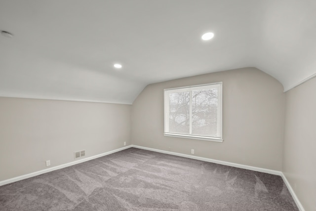 bonus room with vaulted ceiling and carpet