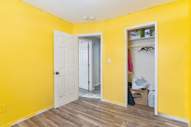 unfurnished bedroom featuring hardwood / wood-style floors and a closet