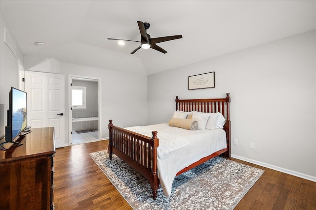 bedroom with vaulted ceiling, ceiling fan, dark hardwood / wood-style flooring, and ensuite bath