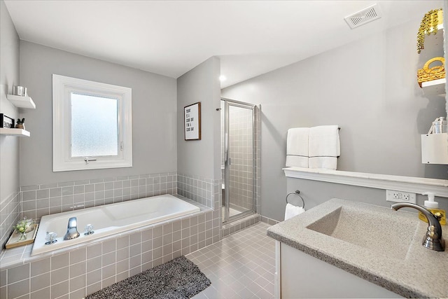 bathroom with tile patterned flooring, vanity, and separate shower and tub