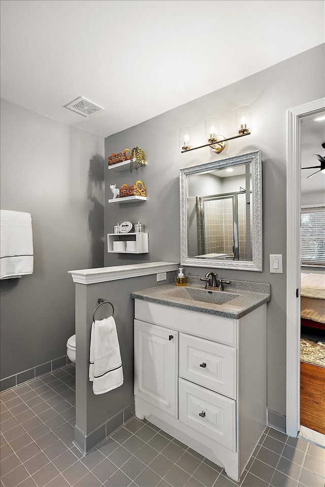 bathroom featuring vanity, tile patterned floors, toilet, and walk in shower