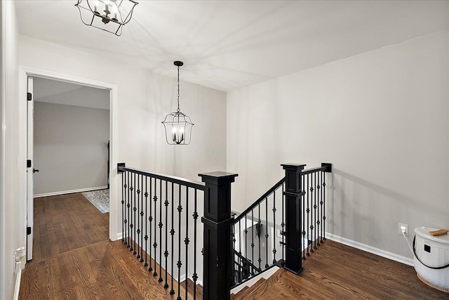 hallway featuring dark hardwood / wood-style flooring and an inviting chandelier