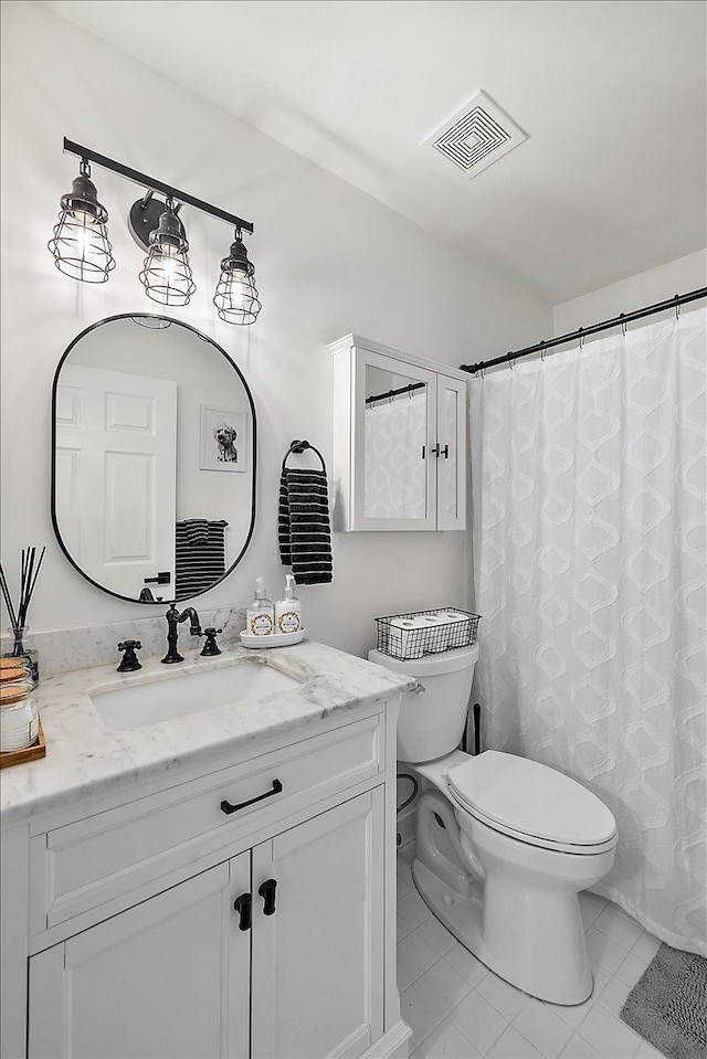 bathroom with vanity, curtained shower, tile patterned floors, and toilet