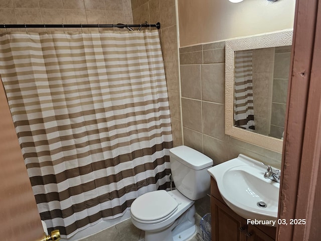 bathroom with vanity, tile walls, and toilet