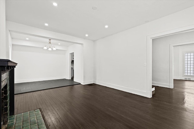 unfurnished living room with dark wood-type flooring and a notable chandelier