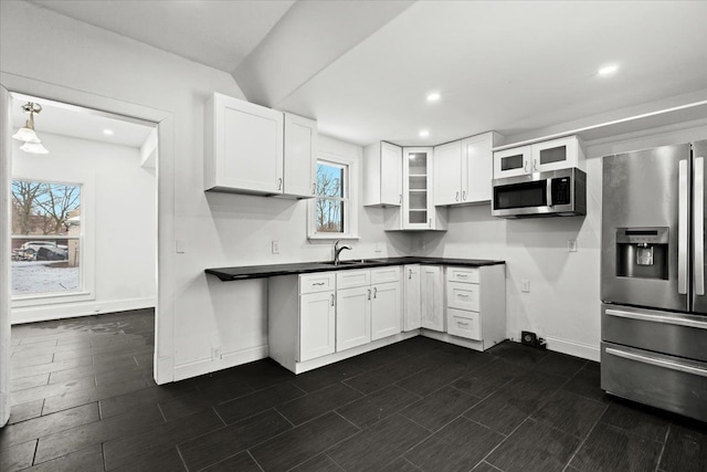 kitchen with appliances with stainless steel finishes, decorative light fixtures, sink, and white cabinets