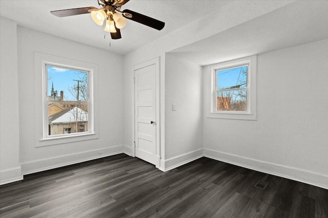 unfurnished bedroom with ceiling fan and dark wood-type flooring