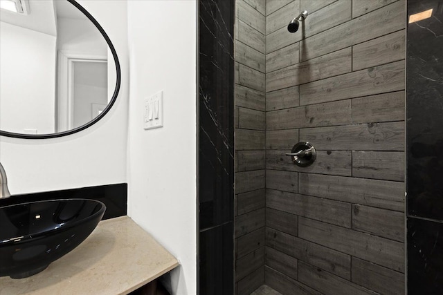 bathroom featuring sink and a tile shower