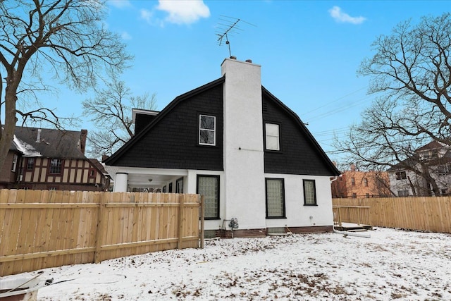 view of snow covered back of property