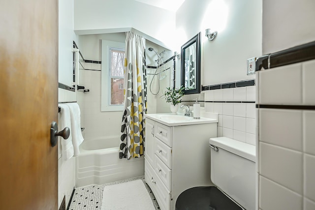 full bathroom with toilet, shower / tub combo, tile walls, vanity, and tile patterned flooring