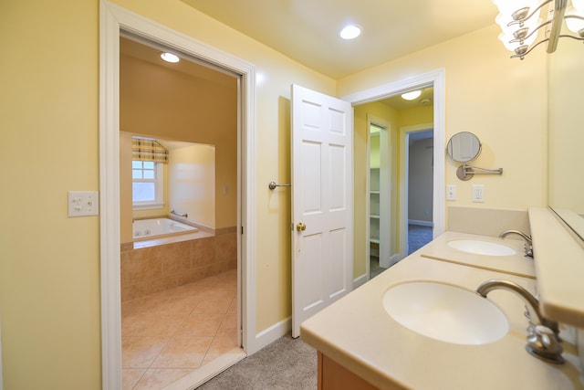 bathroom featuring vanity, a relaxing tiled tub, and tile patterned floors