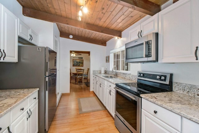 kitchen with sink, light stone countertops, white cabinets, and appliances with stainless steel finishes