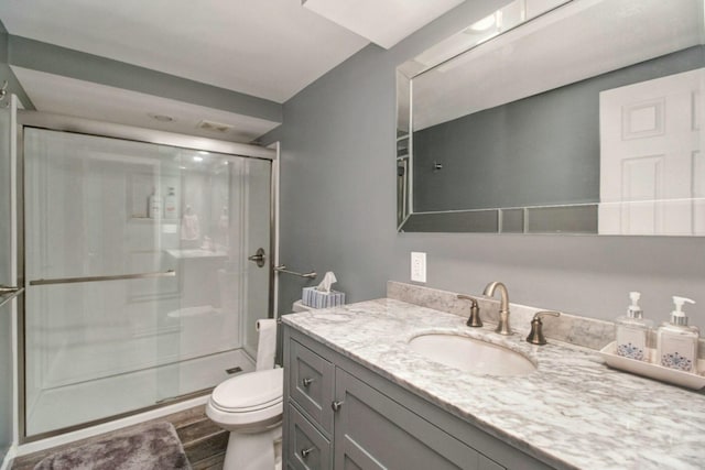 bathroom with hardwood / wood-style flooring, vanity, walk in shower, and toilet