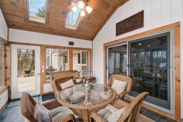 sunroom / solarium featuring ceiling fan, vaulted ceiling with skylight, and wood ceiling