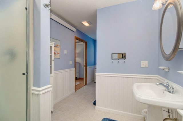 bathroom with sink, a shower with shower door, and tile patterned flooring