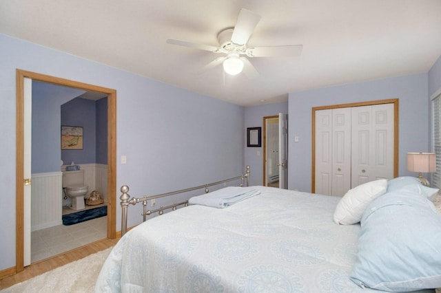 bedroom featuring ceiling fan, connected bathroom, a closet, and light hardwood / wood-style flooring