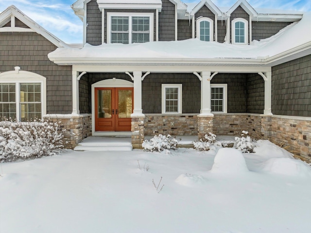 snow covered property entrance featuring french doors