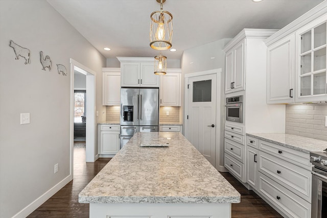 kitchen with pendant lighting, a center island, white cabinets, and appliances with stainless steel finishes