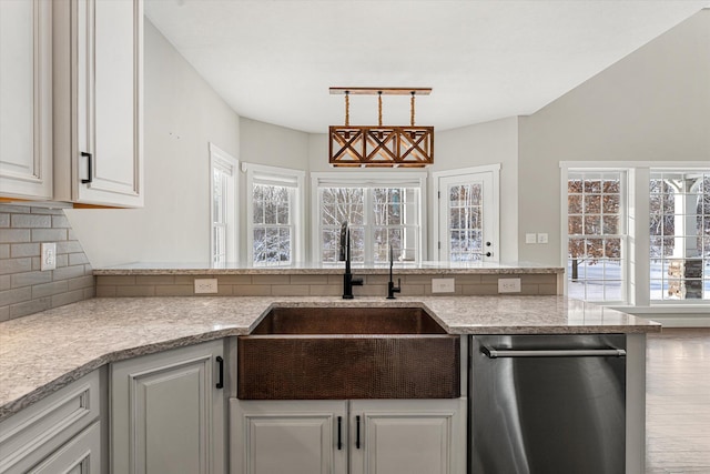 kitchen featuring sink, backsplash, dishwasher, pendant lighting, and white cabinets