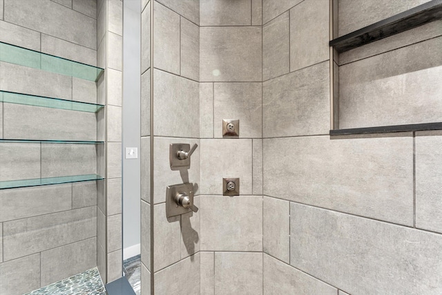 interior details featuring a tile shower