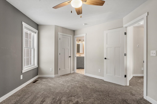 unfurnished bedroom featuring ceiling fan, ensuite bathroom, and carpet floors