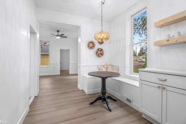 dining space with breakfast area, ceiling fan, and light wood-type flooring