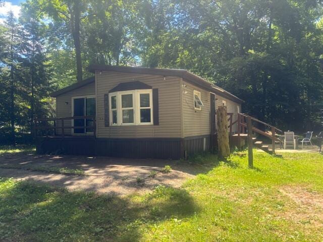 view of side of home featuring a wooden deck and a lawn