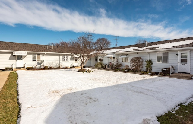 view of snow covered back of property