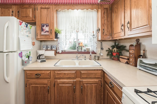 kitchen with white fridge, sink, and stove