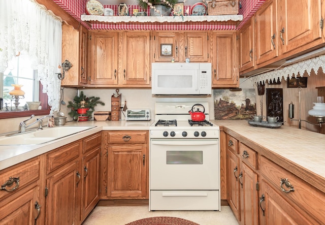 kitchen featuring white appliances and sink