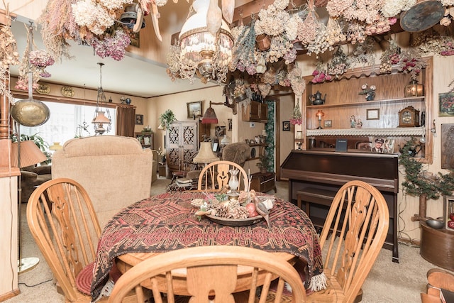 dining room with crown molding and light carpet