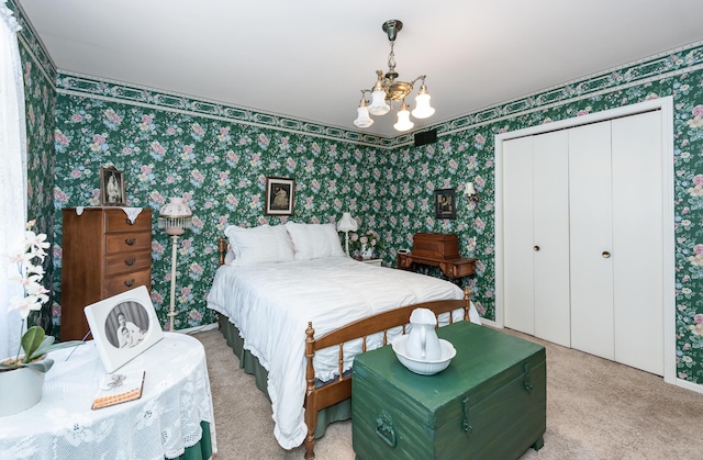 carpeted bedroom with a chandelier and a closet