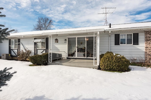 snow covered house with central air condition unit