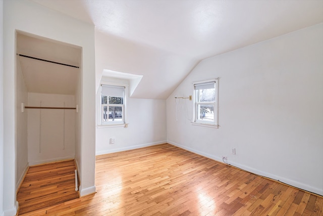 additional living space featuring vaulted ceiling and light hardwood / wood-style floors