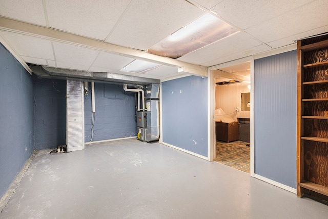 basement featuring heating unit and a paneled ceiling