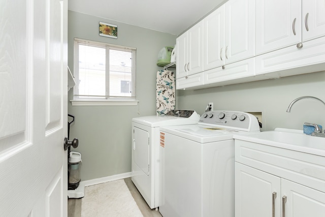 washroom featuring sink, cabinets, and washing machine and clothes dryer